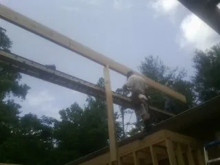 Carpenter setting a ridge beam over a new addition frame — Ice Dam Removal by Roofing Brothers in Campti
