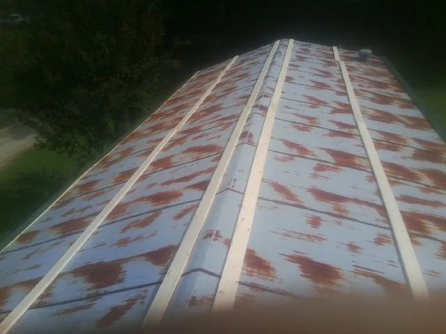 Rusted metal roof panels with new wood purlins before replacement — Storm Damage Roof Repair in Campti by Roofing Brothers
