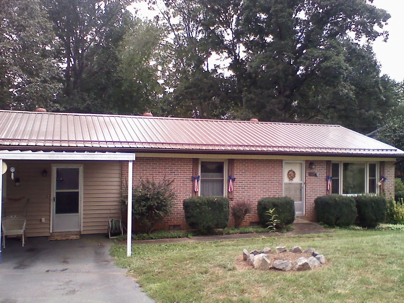 Bronze metal roof and carport on a brick ranch home — Roof Repair work by our crew in Campti