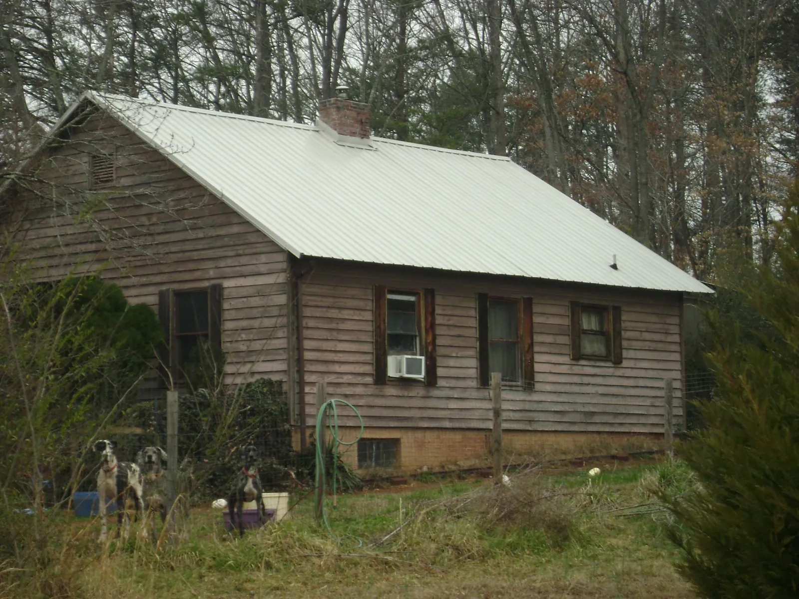 White metal roof on an old wood sided farmhouse, from a Metal Roof Installation job in Campti